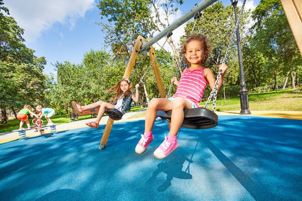 Children playing on swings in a park playground